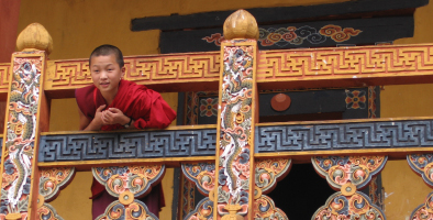 Young Bhutanese monk looking from the balcony